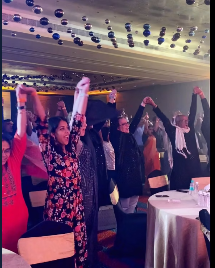 Guests cheering with arms raised at a gala celebration