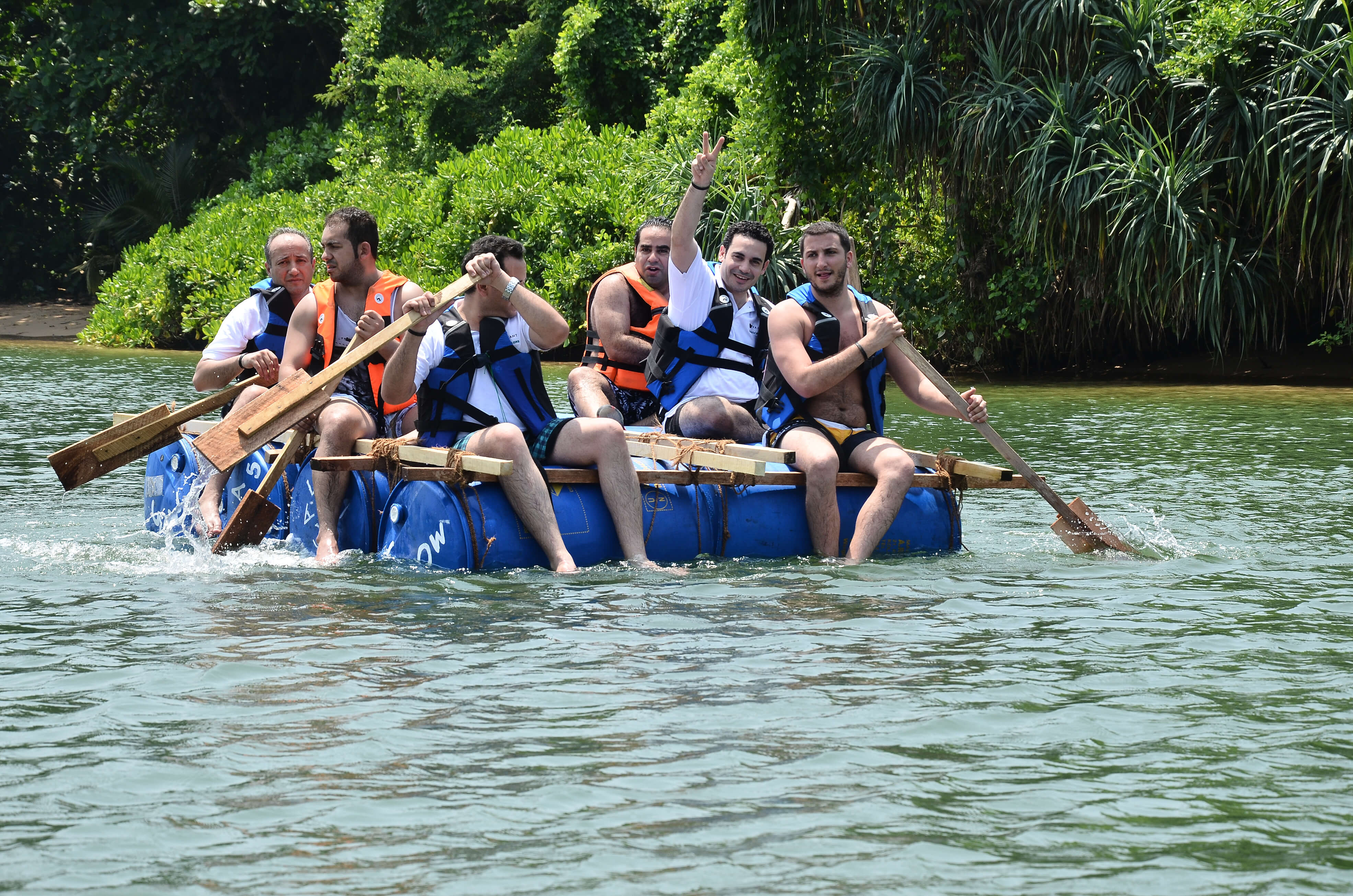 Team paddling a raft together during an adventure offsite